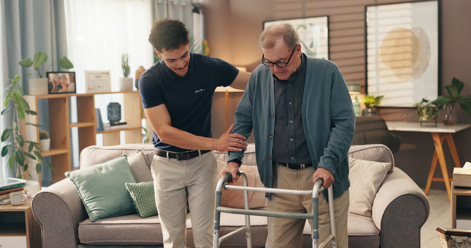 Old man, caregiver and help with walker in home for mobility support, assistance or rehabilitation. Health worker, senior person and walking guide in assisted living facility for balance and recovery